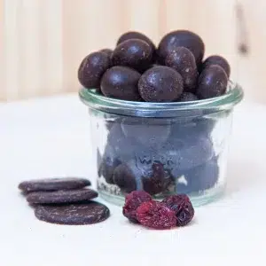Appréciez nos choco cranberries noir, une combinaison parfaite de cranberries acidulées et de chocolat noir intense. Chaque bouchée vous offre un contraste exquis entre le goût légèrement acidulé des cranberries séchées et la profondeur du chocolat noir haut de gamme. Enveloppées dans une riche couche de chocolat noir, ces cranberries dévoilent une explosion de saveurs sucrées et fruitées, complétées par les arômes puissants du cacao. Ce mariage de textures entre le croquant du chocolat et la douceur des cranberries crée une expérience de dégustation à la fois gourmande et équilibrée. Parfaites pour une pause sucrée ou comme en-cas raffiné, nos choco cranberries noir sont idéales pour satisfaire vos envies de douceur avec une touche d’élégance et de sophistication.