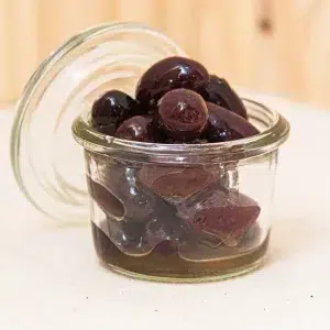 Découvrez nos olives Kalamata avec noyaux, un classique de la cuisine méditerranéenne qui ravira les amateurs de saveurs authentiques. Ces olives, cultivées en Grèce, arborent une couleur violette profonde et une saveur généreuse et complexe. Le noyau, conservé pour préserver toute la richesse du goût, offre une texture parfaite qui se prête aussi bien aux apéritifs qu’aux plats cuisinés. Que vous les serviez en antipasti, dans une salade ou en accompagnement de vos plats principaux, ces olives Kalamata avec noyaux apportent une touche méditerranéenne irrésistible. Savourez le goût authentique de la Grèce avec chaque bouchée de ces olives exceptionnelles.